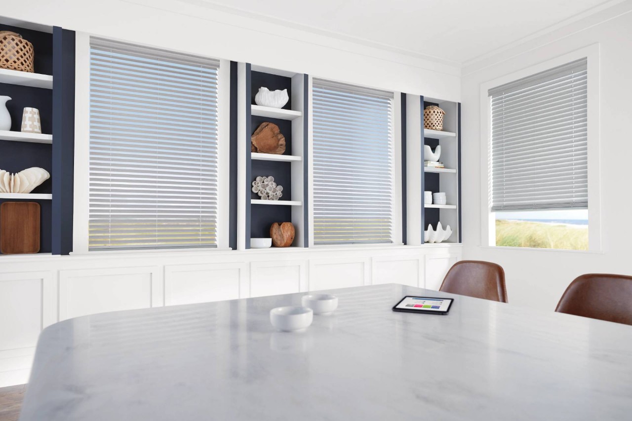 Sleek and modern home interior with a white color scheme and Hunter Douglas EverWood® Alternative Wood Blinds on the windows near Seattle, WA